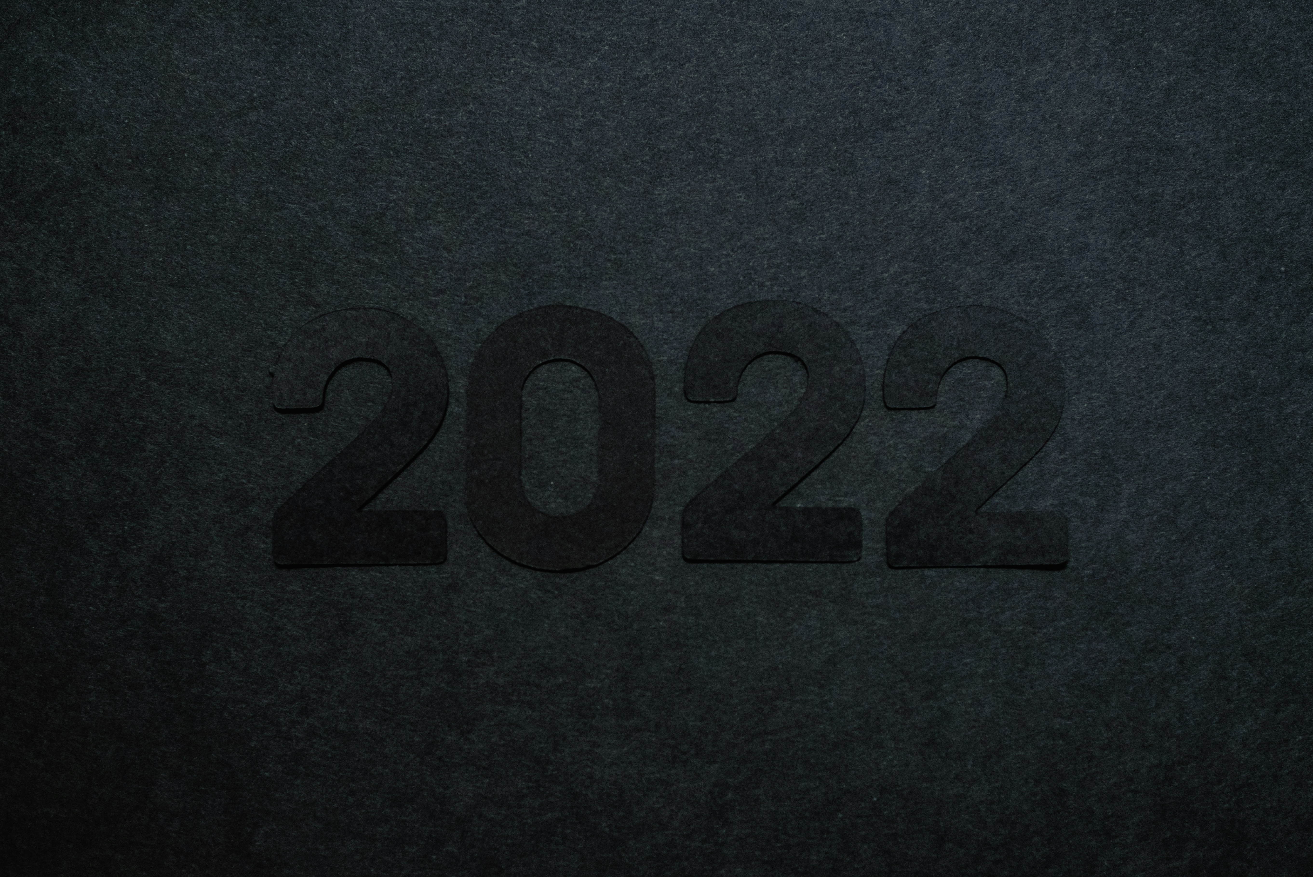 2022 cut out of black paper on top of a sheet of black paper