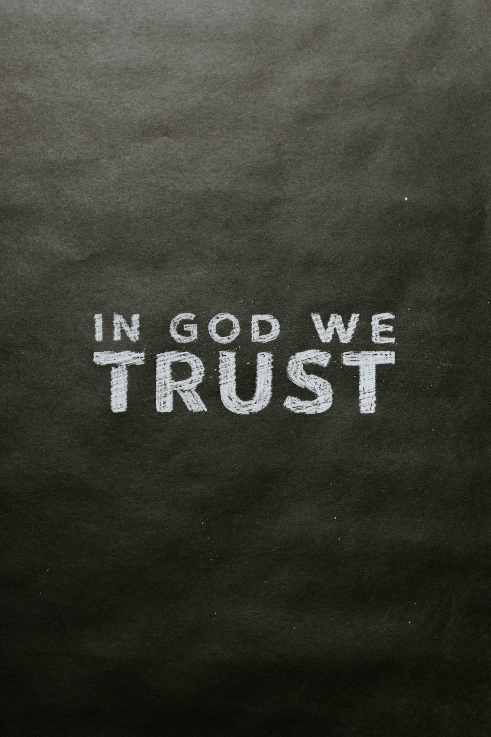 a blackboard with the words in god we trust written on it