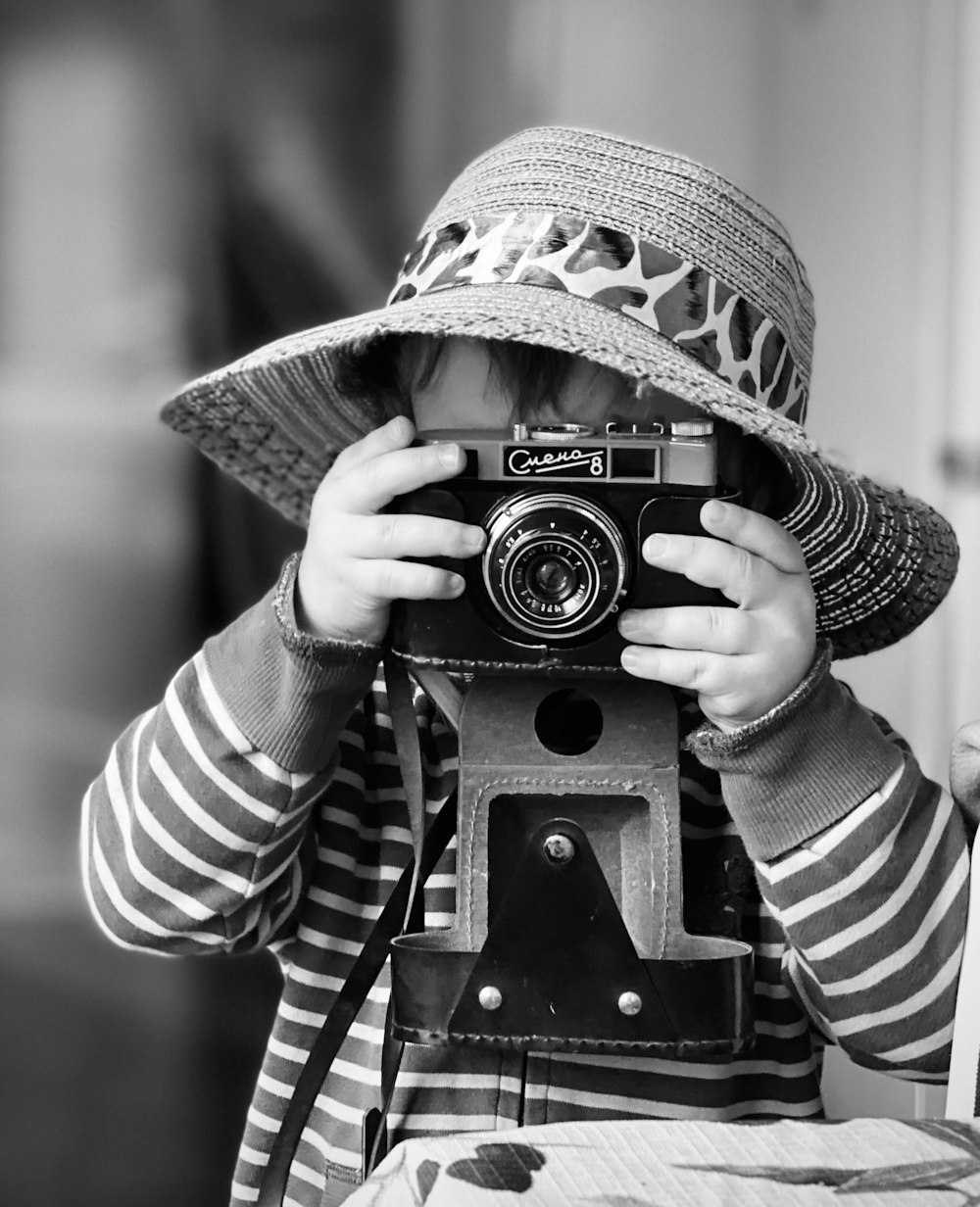 a little boy that is holding a camera