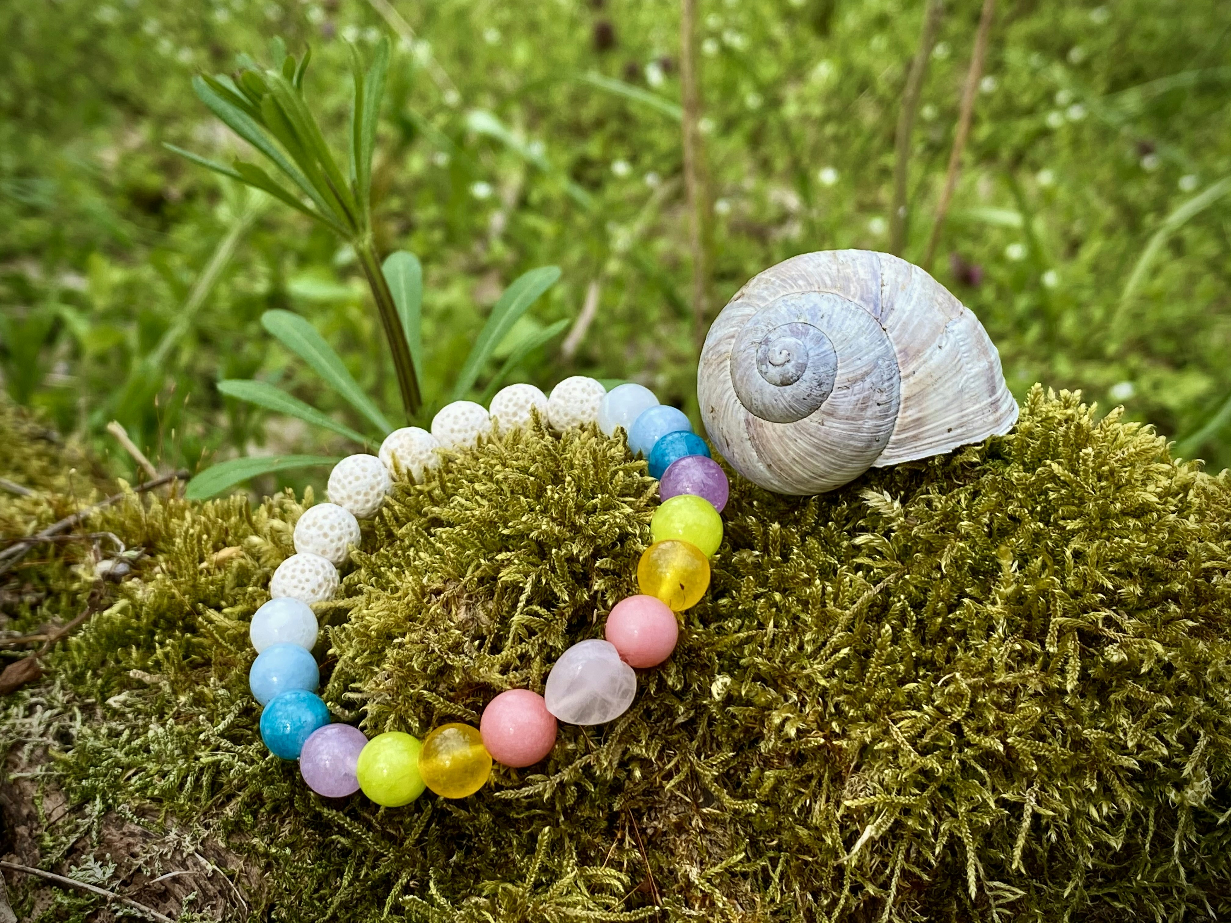 a snail is sitting on a mossy surface