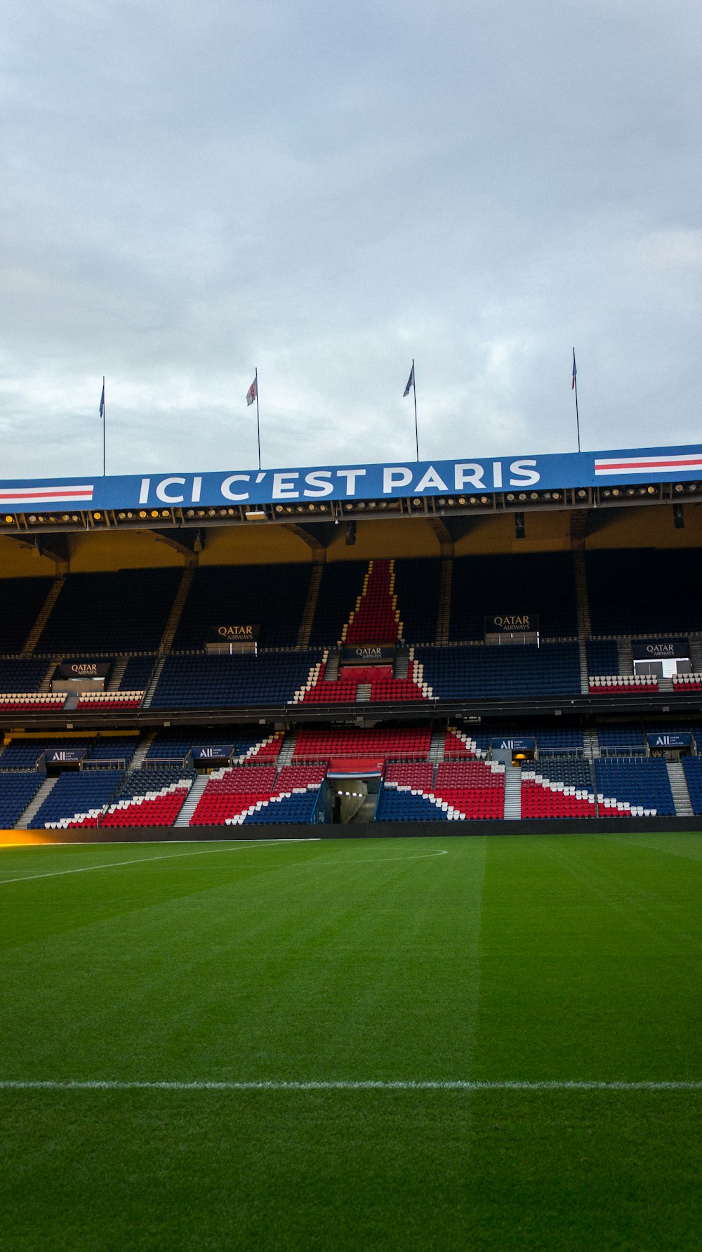 a stadium with a green field and red and blue seats