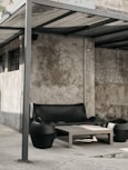 a couch and table under a shelter on a sidewalk