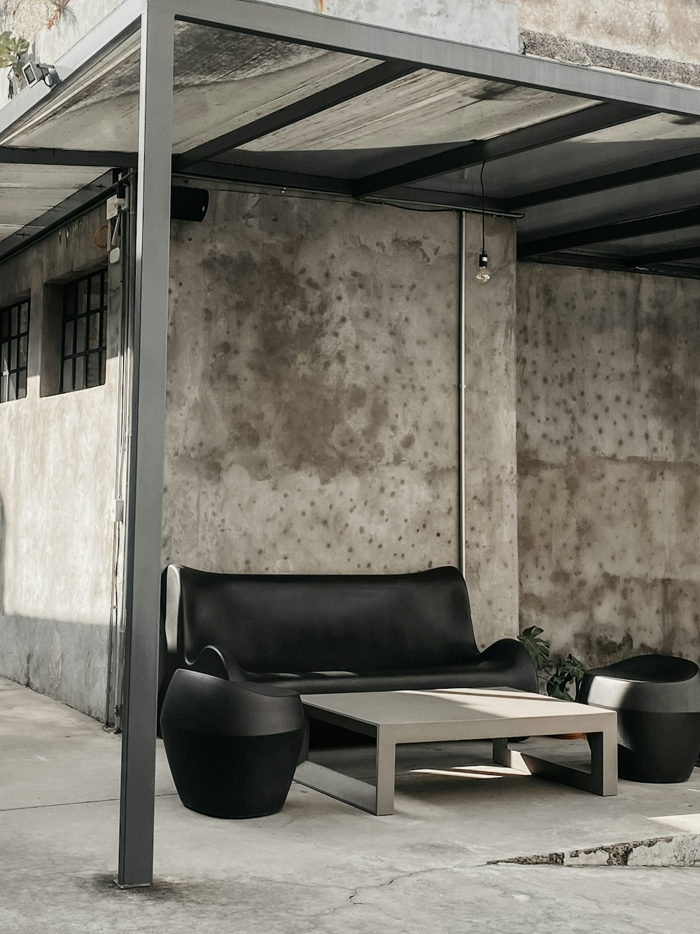 a couch and table under a shelter on a sidewalk