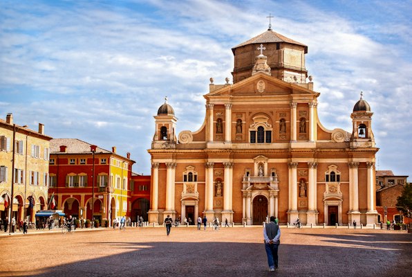 A person standing in front of a large building — Parma, Italy