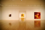 A serene gallery space featuring abstract spiritual paintings on textured walls.