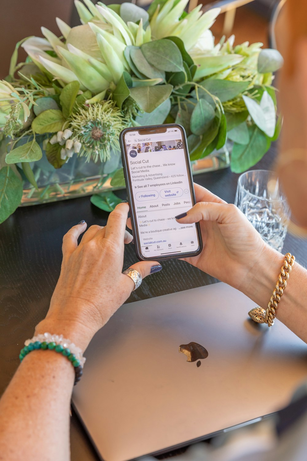 a woman sitting at a table using a cell phone