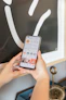 Close-up of a construction worker's hands holding a smartphone displaying social media analytics.