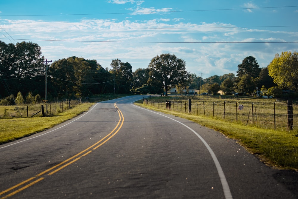 an empty road in the middle of a field