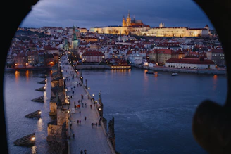 Panoramic view from Prague Castle overlooking the city rooftops and winding river below.