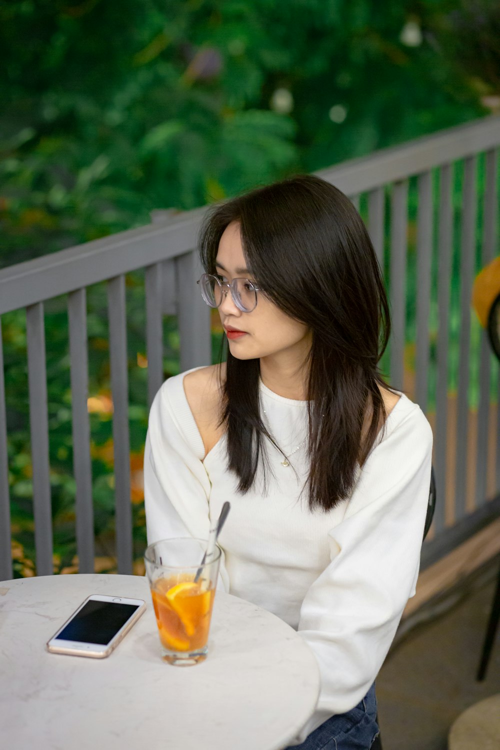 a woman sitting at a table with a glass of orange juice