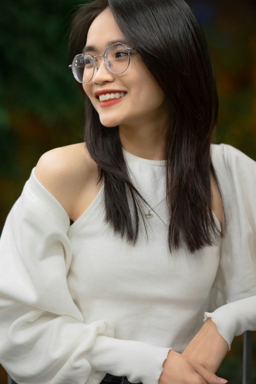 a woman wearing glasses and a white top