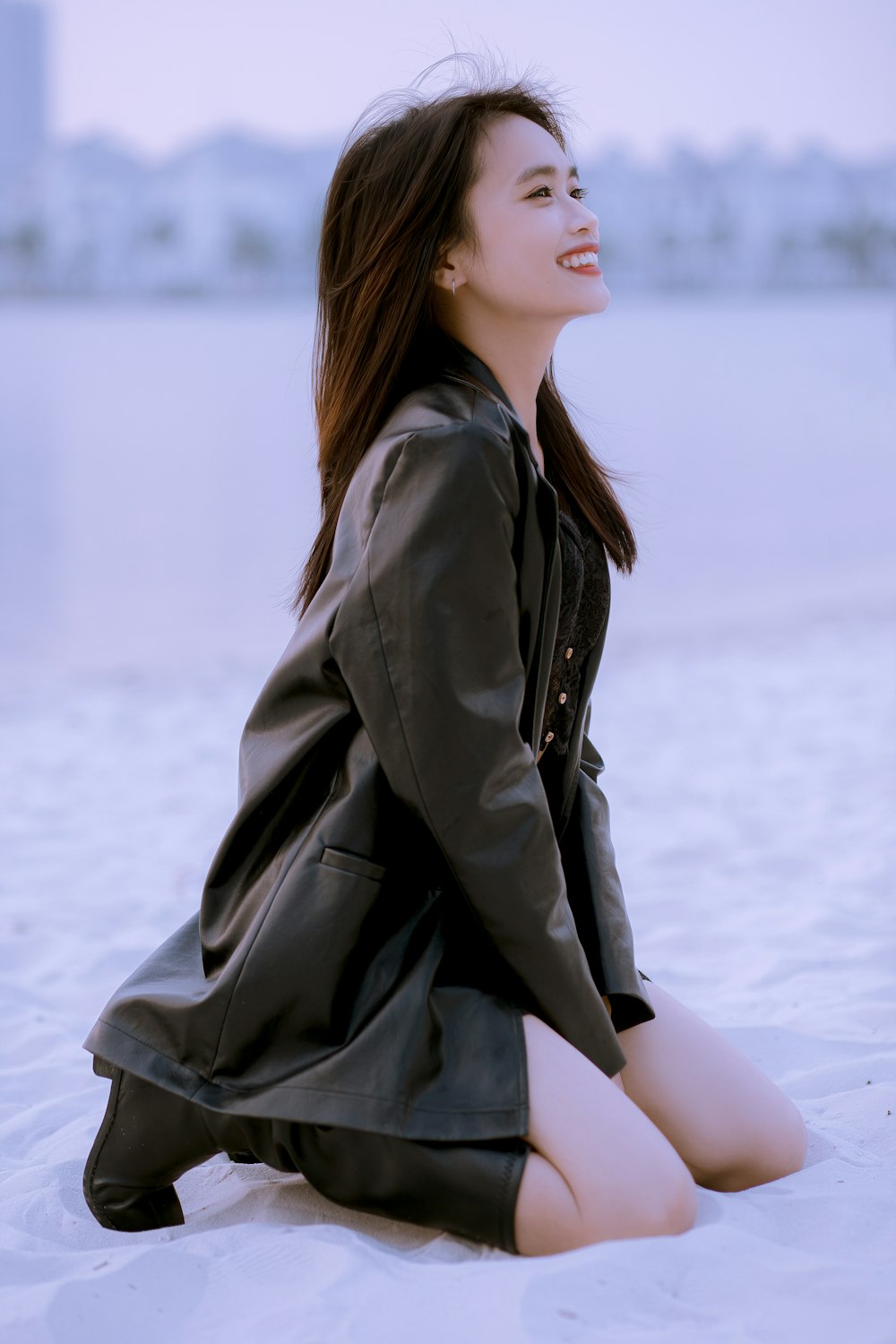 a woman sitting on the ground in a black dress