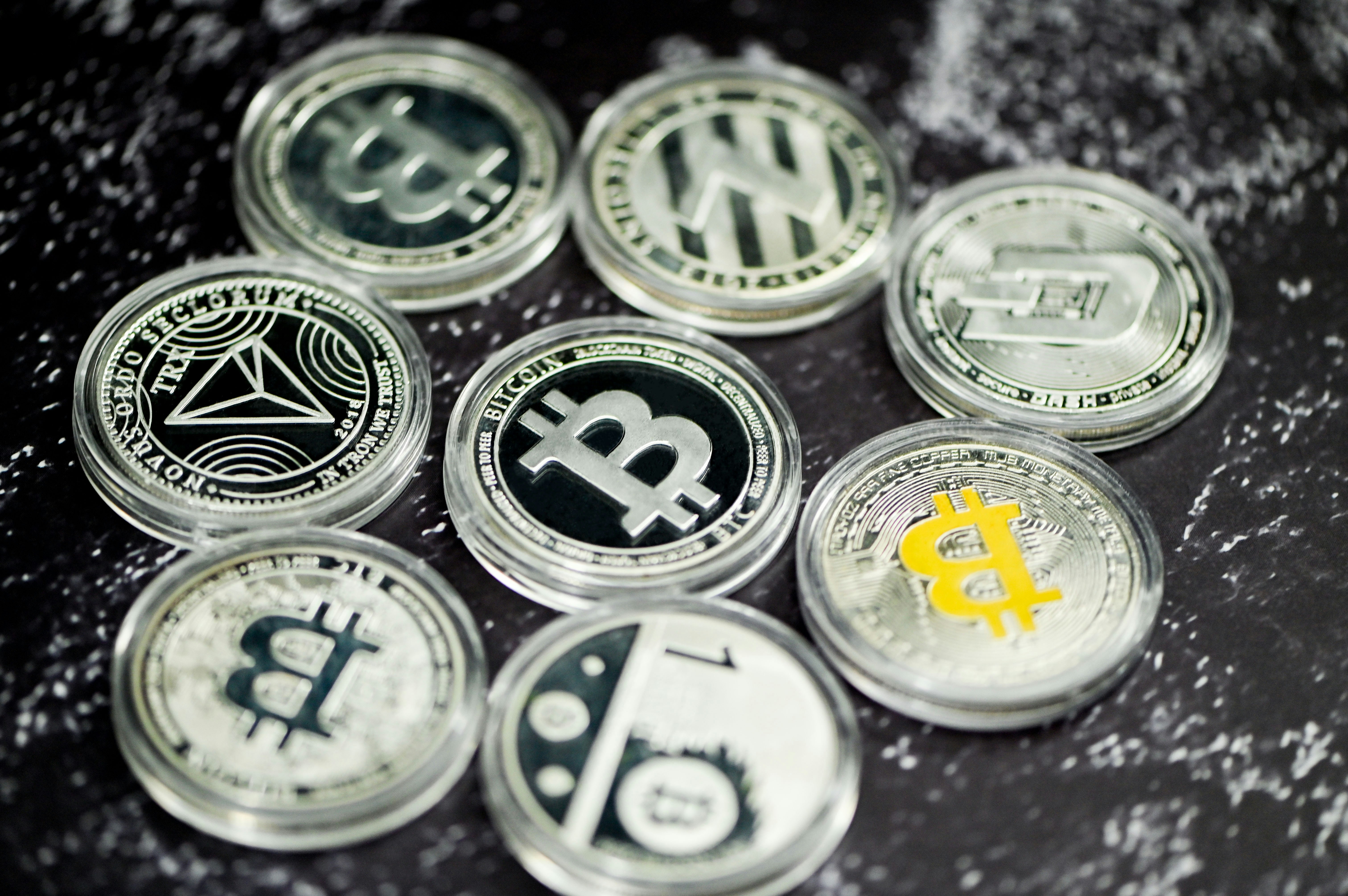 A group of cryptocurrency coins on a marble background