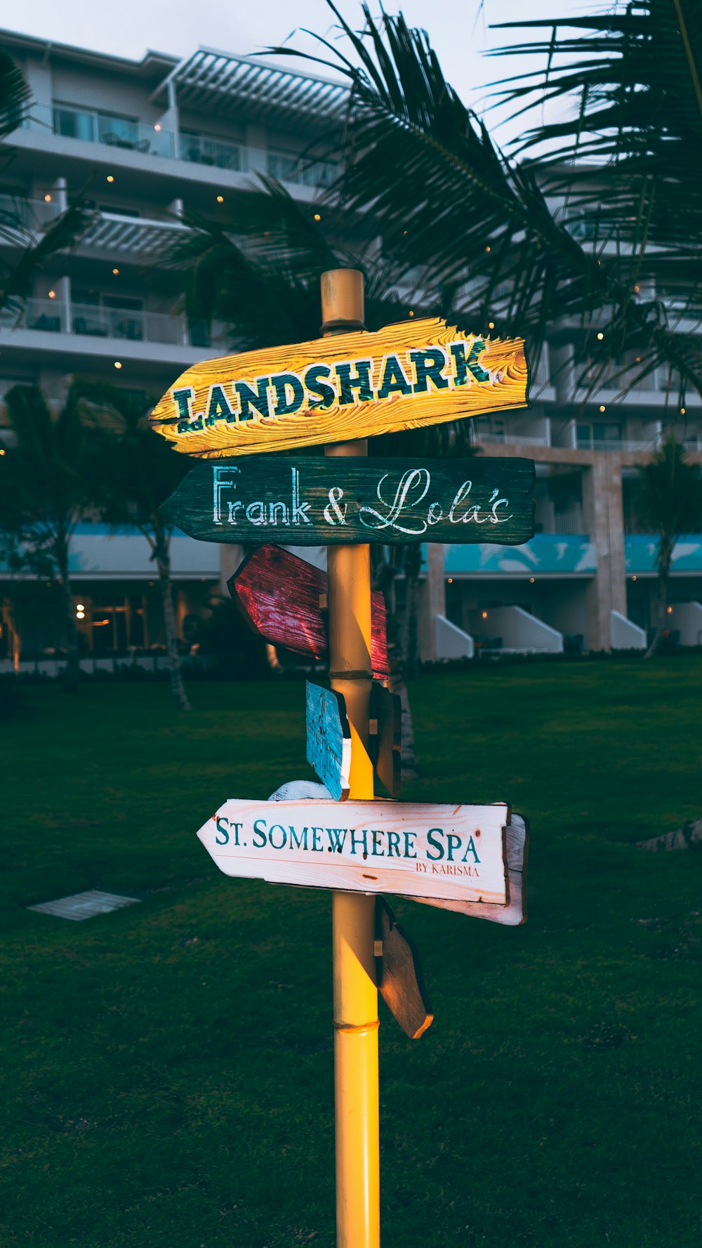 a yellow street sign sitting on the side of a lush green field