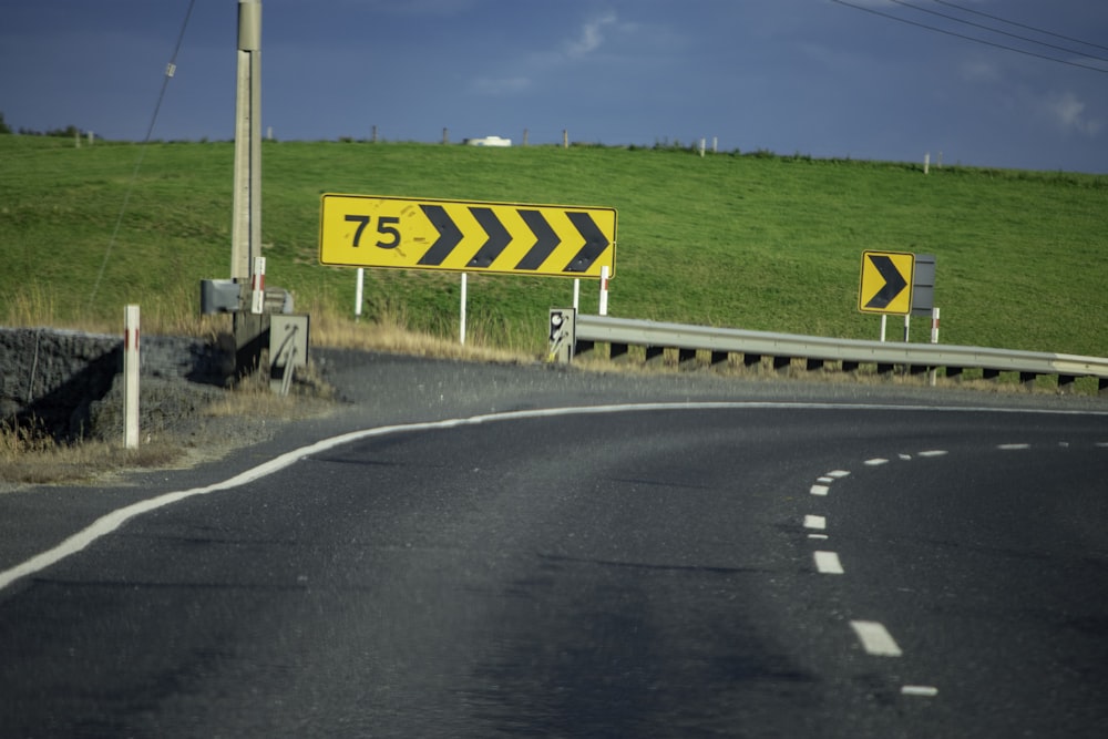 a road with two yellow signs on the side of it