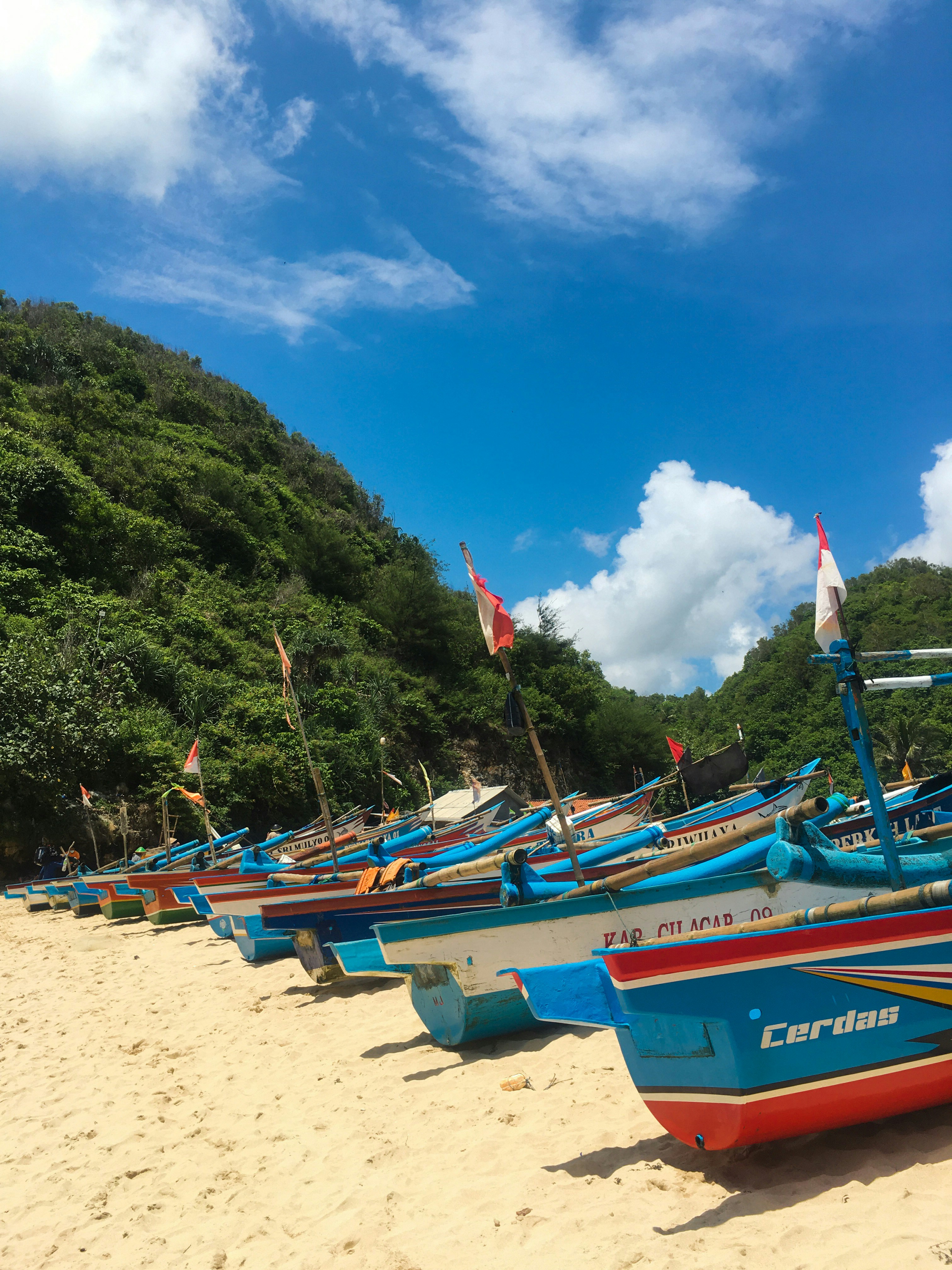 deretan perahu yang duduk di atas pantai berpasir