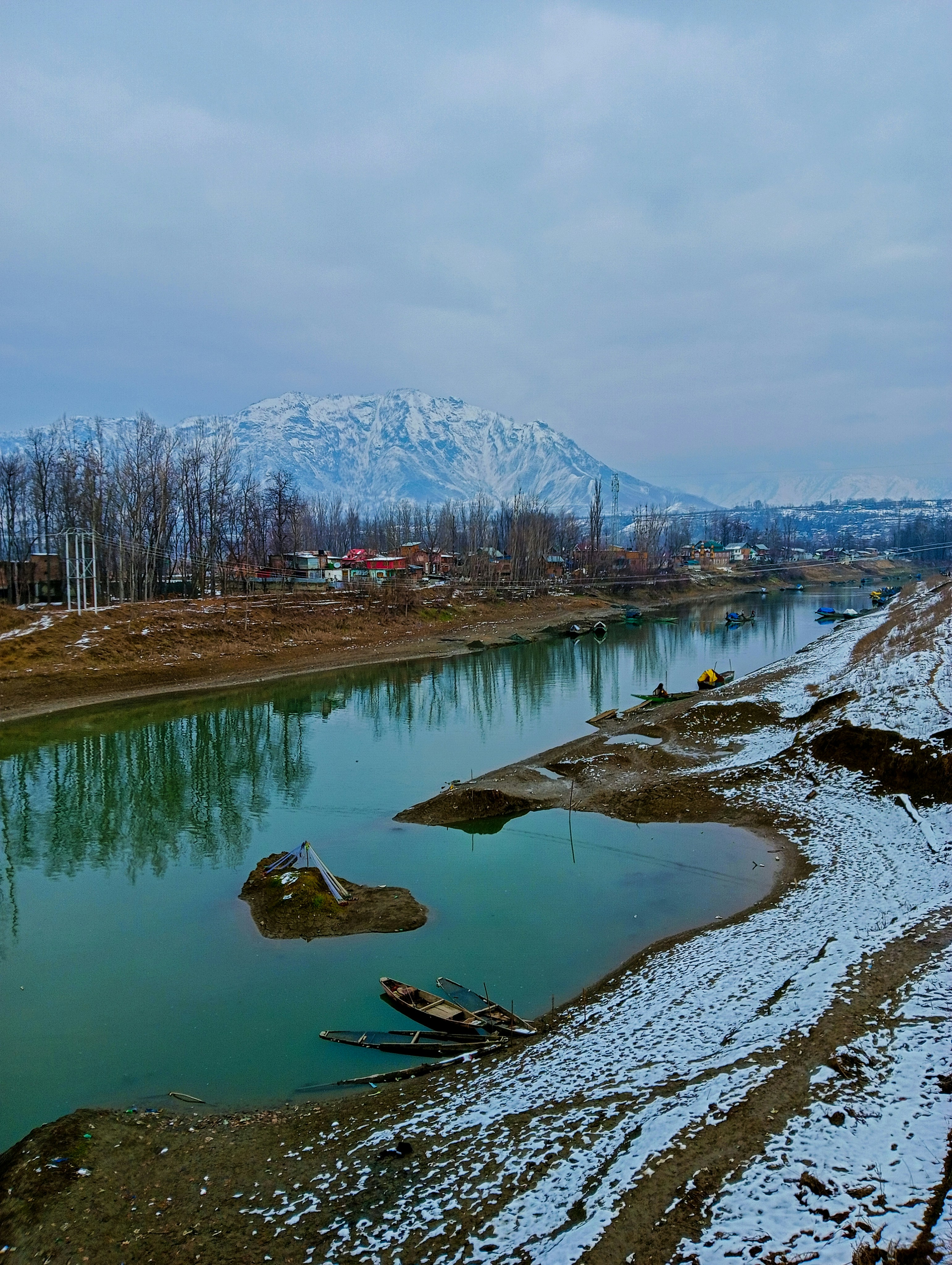 a body of water surrounded by snow covered mountains
