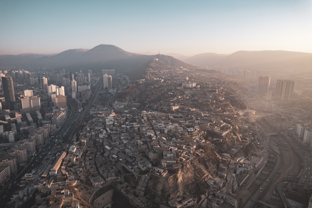 an aerial view of a city with mountains in the background