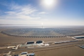 Aerial view of a large-scale solar power plant glowing under the sun.