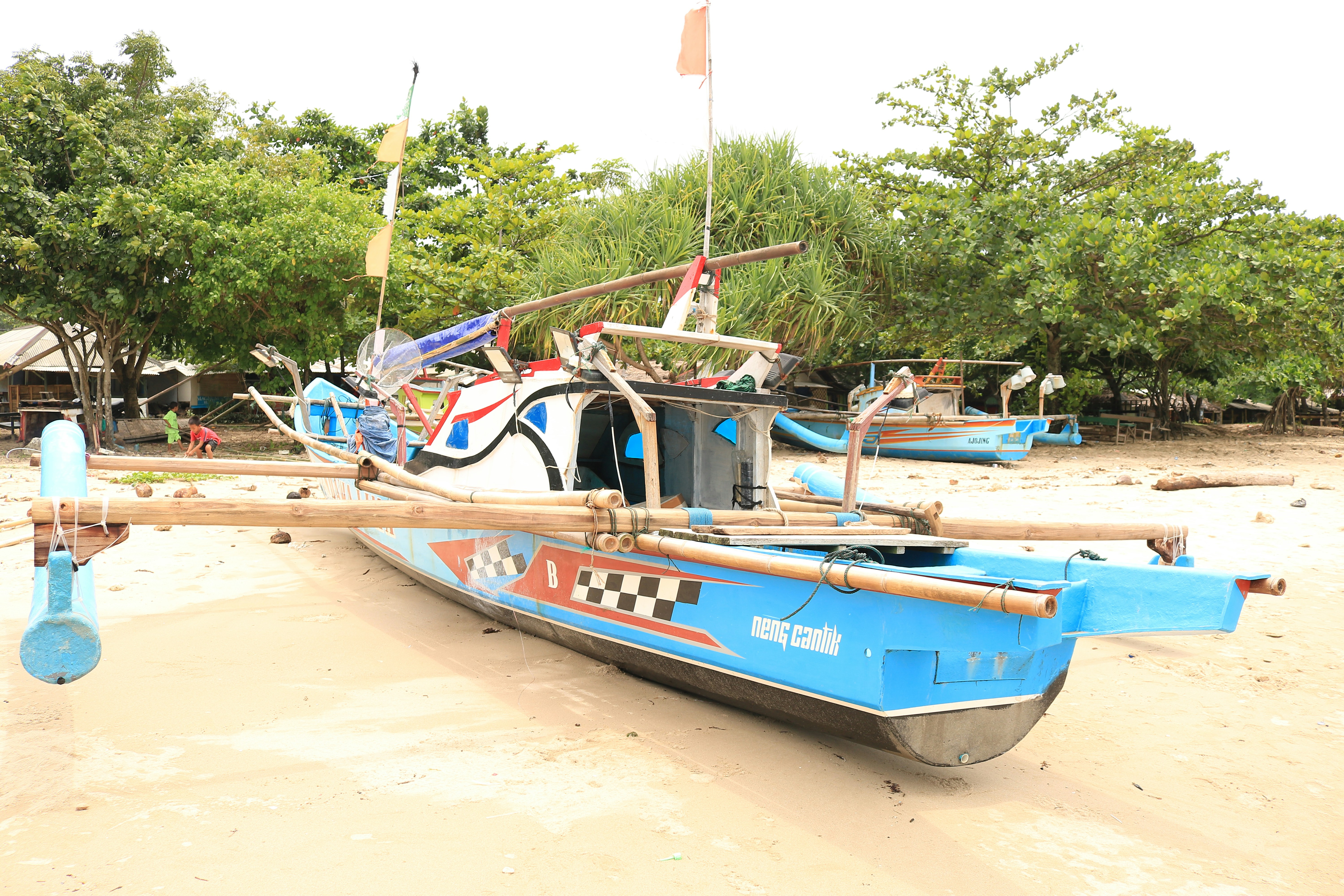 a blue boat sitting on top of a sandy beach