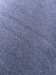 Close-up of breathable fabric texture on a charcoal scrub top.