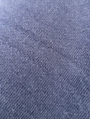 Close-up of premium heavyweight fabric textures in deep charcoal and black tones with silver accents.