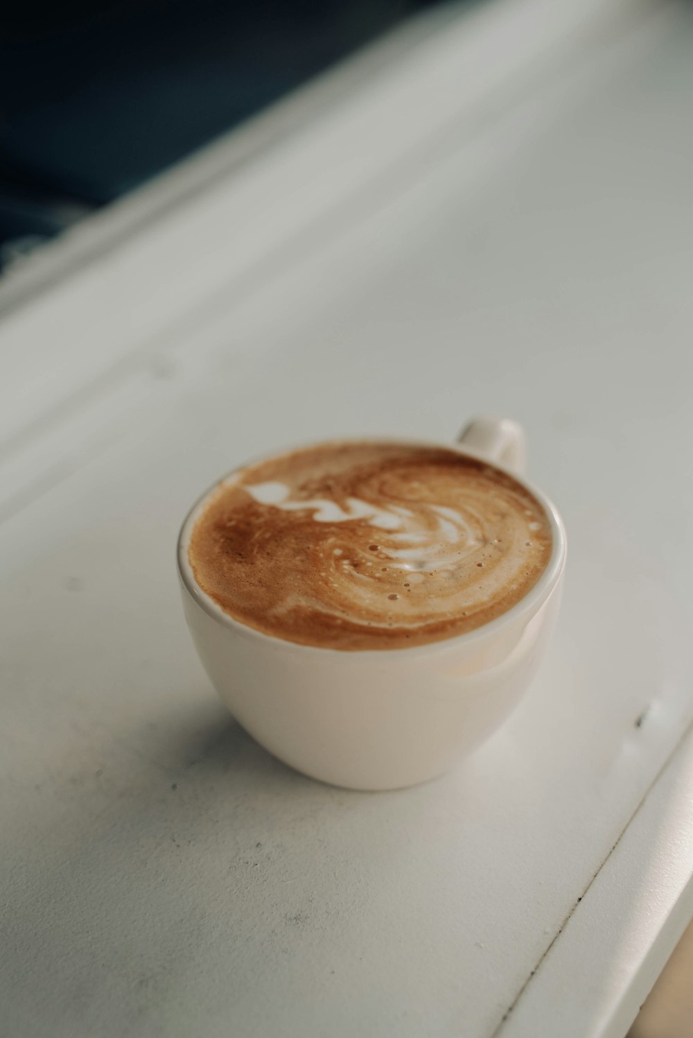 un cappuccino seduto sopra un bancone bianco