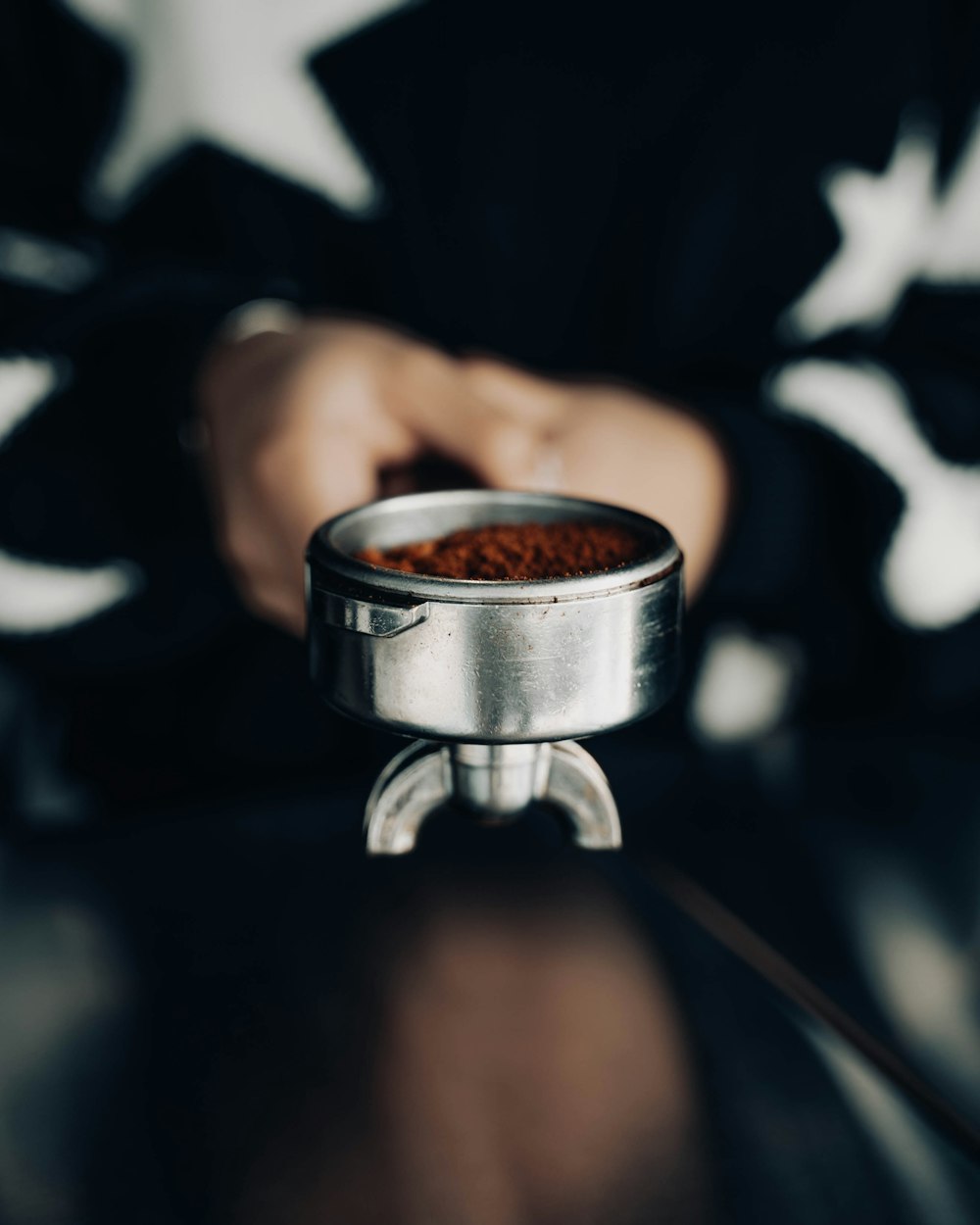 a close up of a person holding a metal container