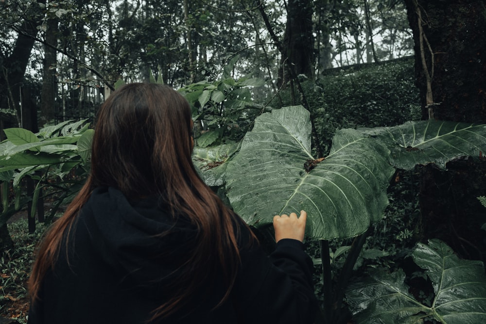 a woman standing in the middle of a forest