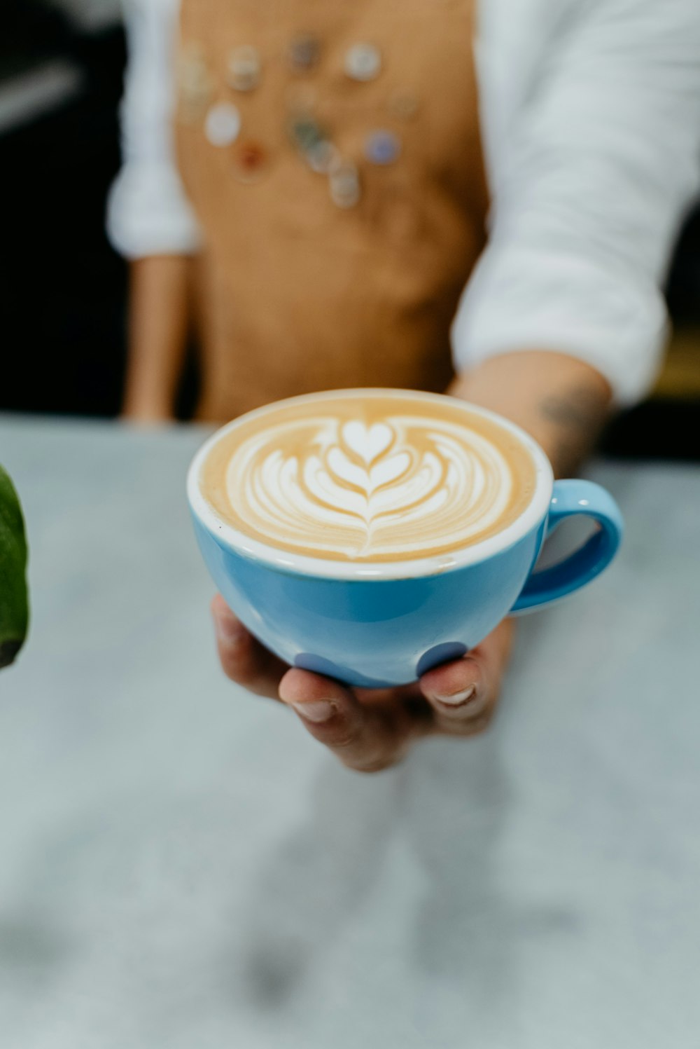 a person holding a cup of coffee in their hand