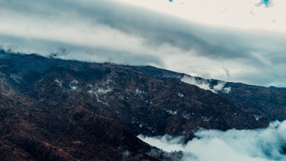 a view of the top of a mountain covered in clouds