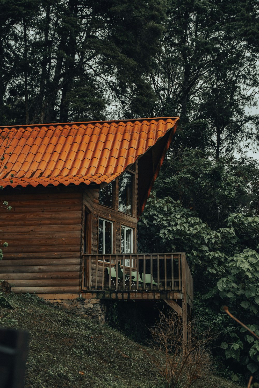 a small wooden cabin with a red tiled roof