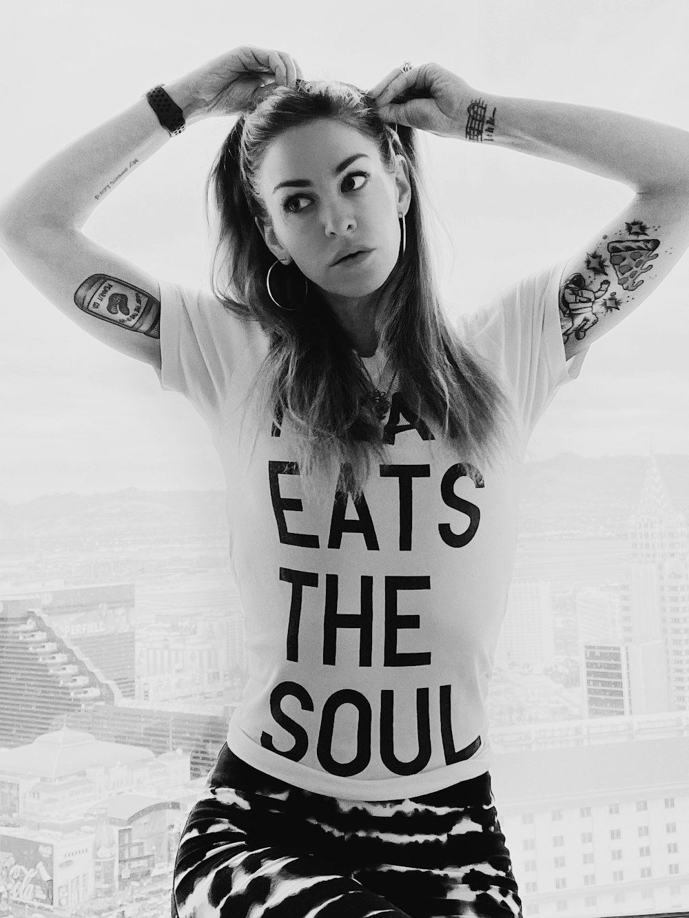 a woman with tattoos and a t - shirt that says eat the soul
