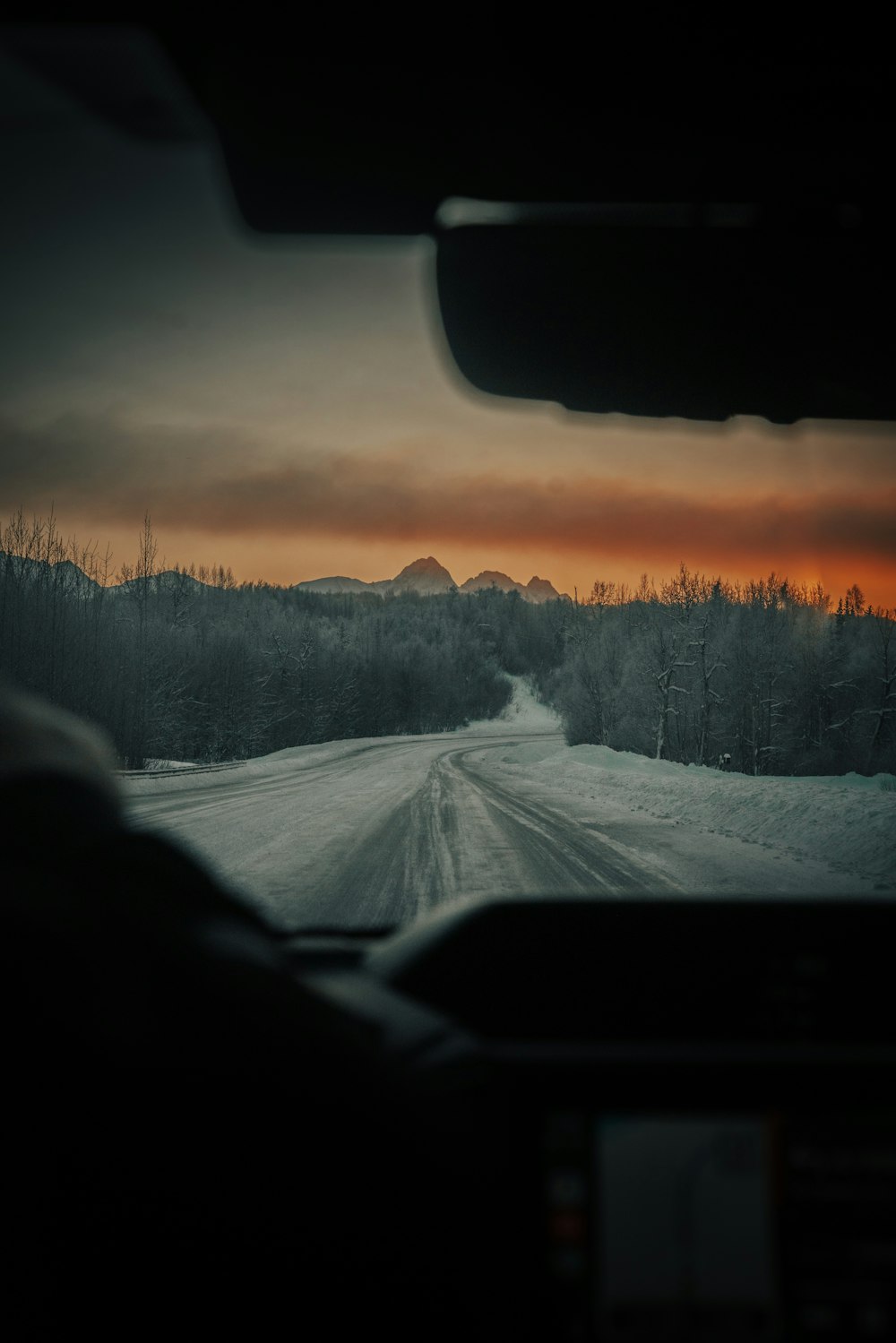 a car driving down a snow covered road