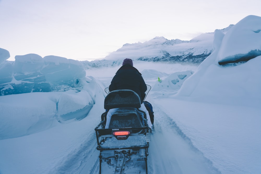 a person riding a sled down a snow covered road