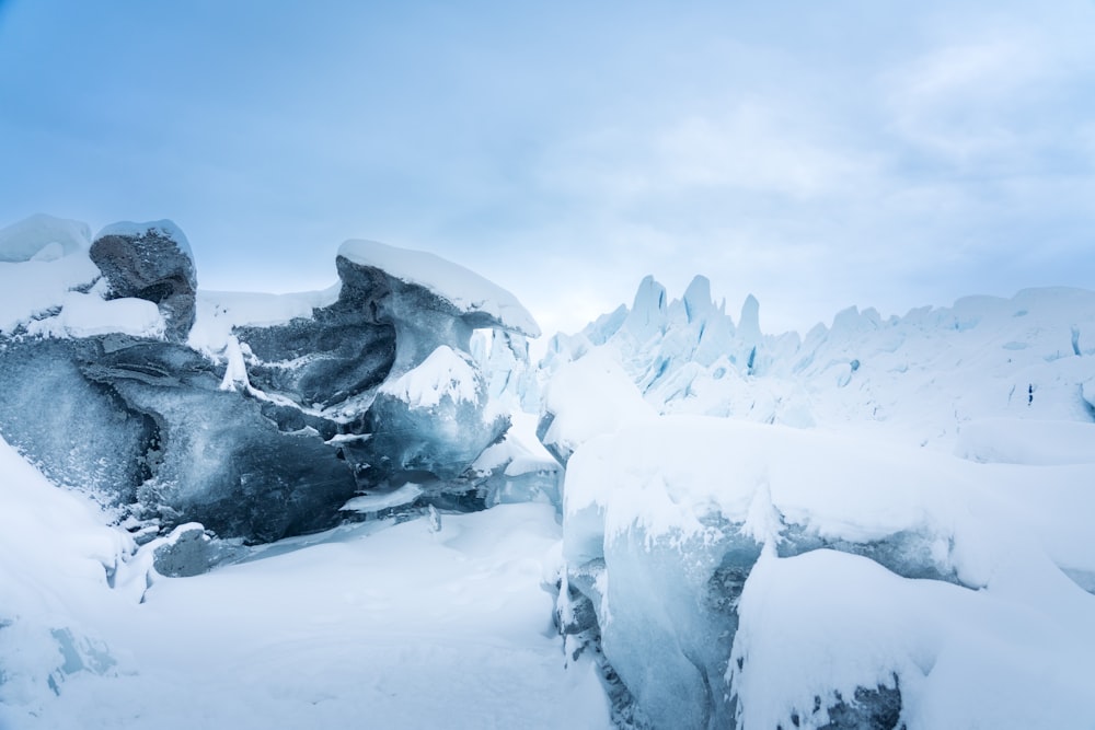 a snow covered mountain with ice formations in the foreground