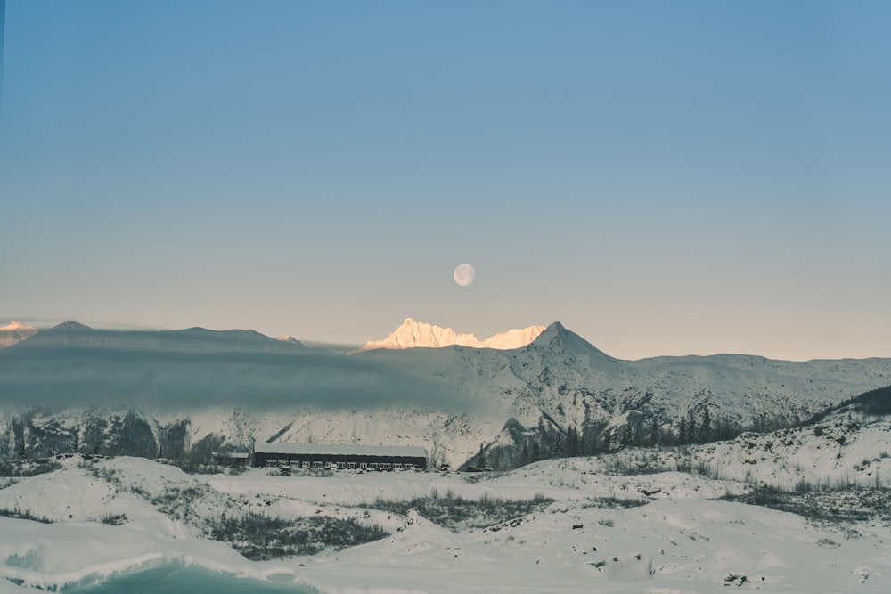 a snowy landscape with mountains in the background