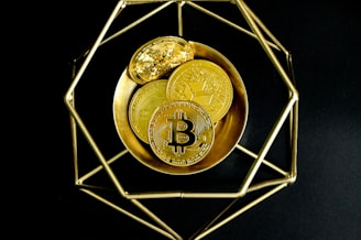 a golden bitcoin sitting on top of a gold plate