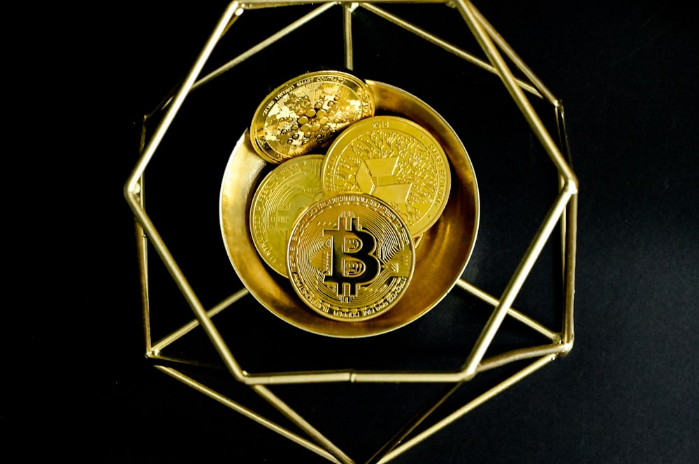 Un bitcoin dorado sentado encima de una placa de oro