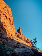 a rocky mountain with a tree on the side of it