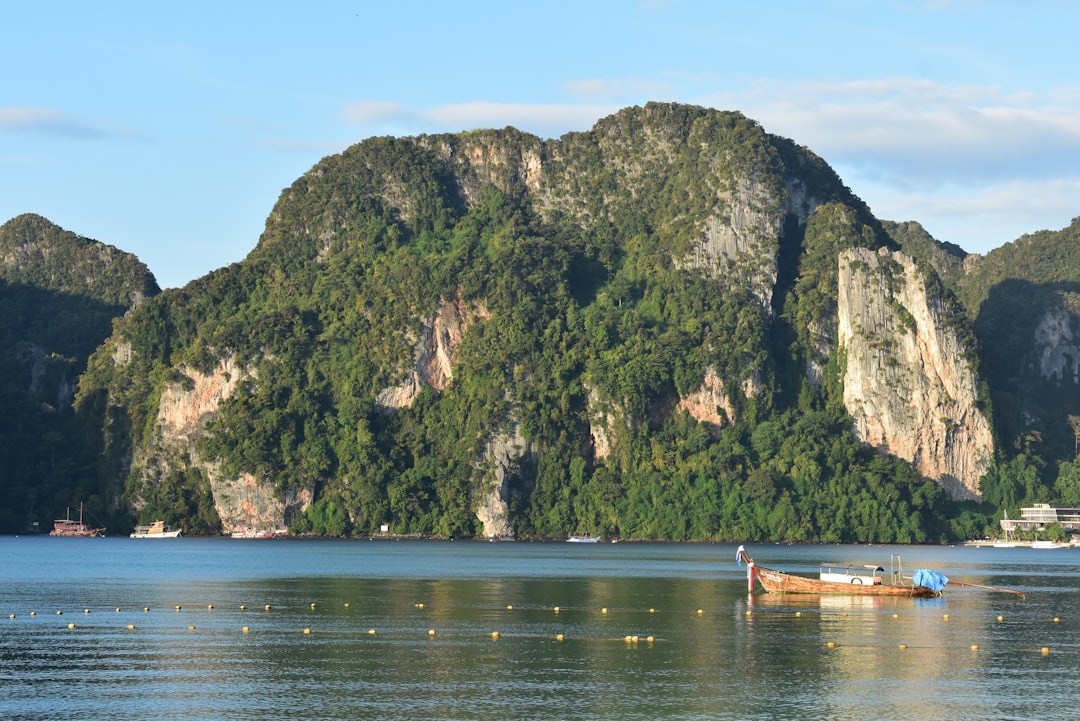 a boat floating on top of a lake surrounded by mountains,