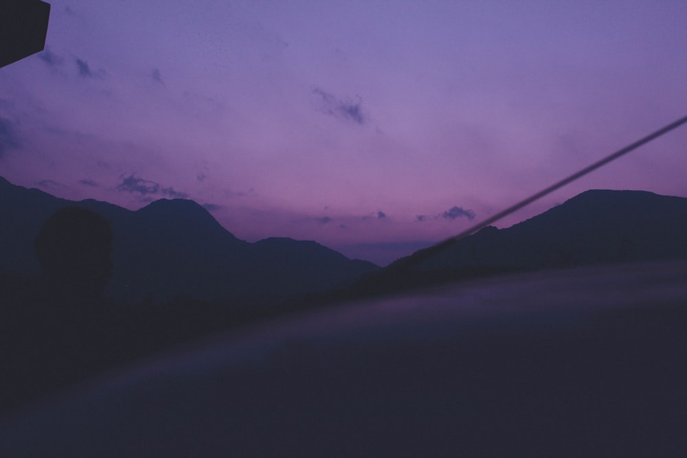 a purple sky with mountains in the background