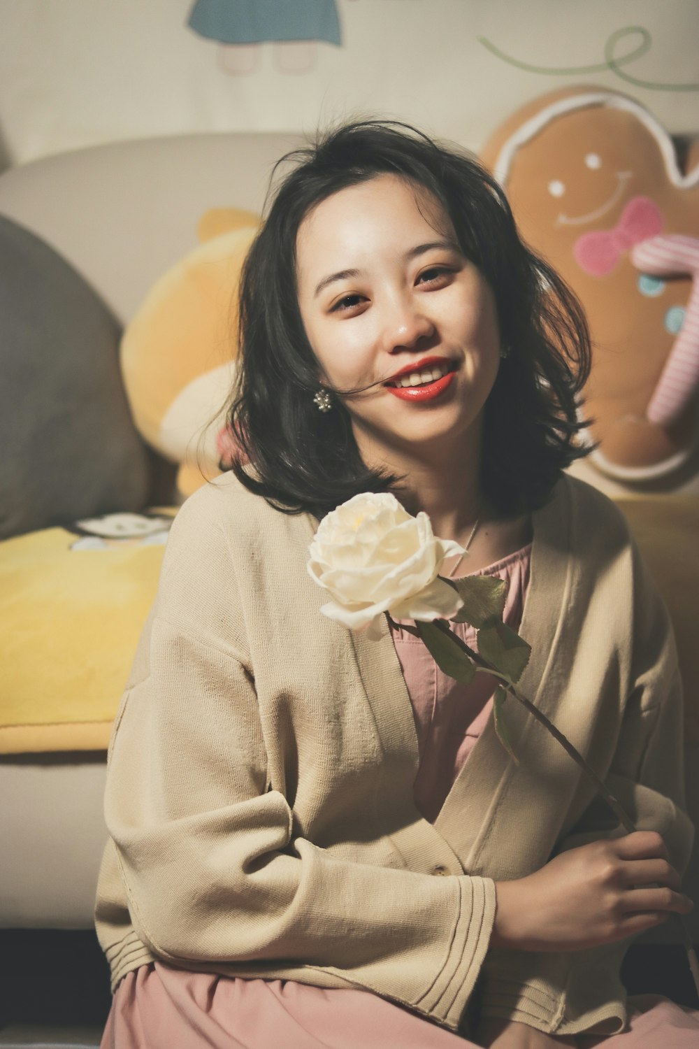 a woman sitting on a couch with a flower in her hand