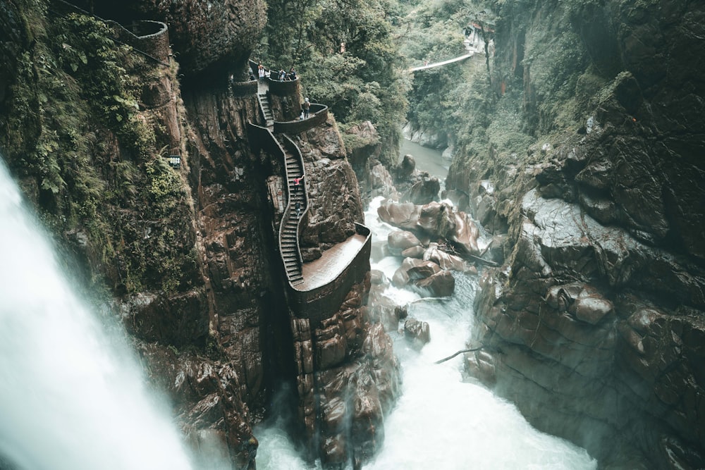 a man walking across a bridge over a river