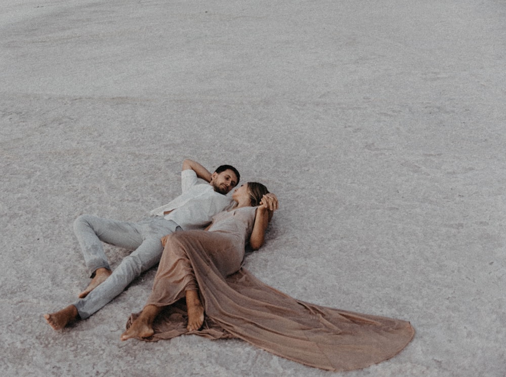 a man and a woman laying on the ground