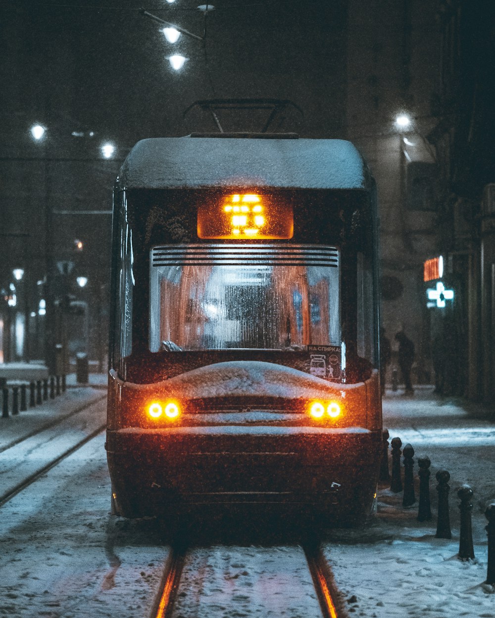 a city bus driving down a snowy street at night