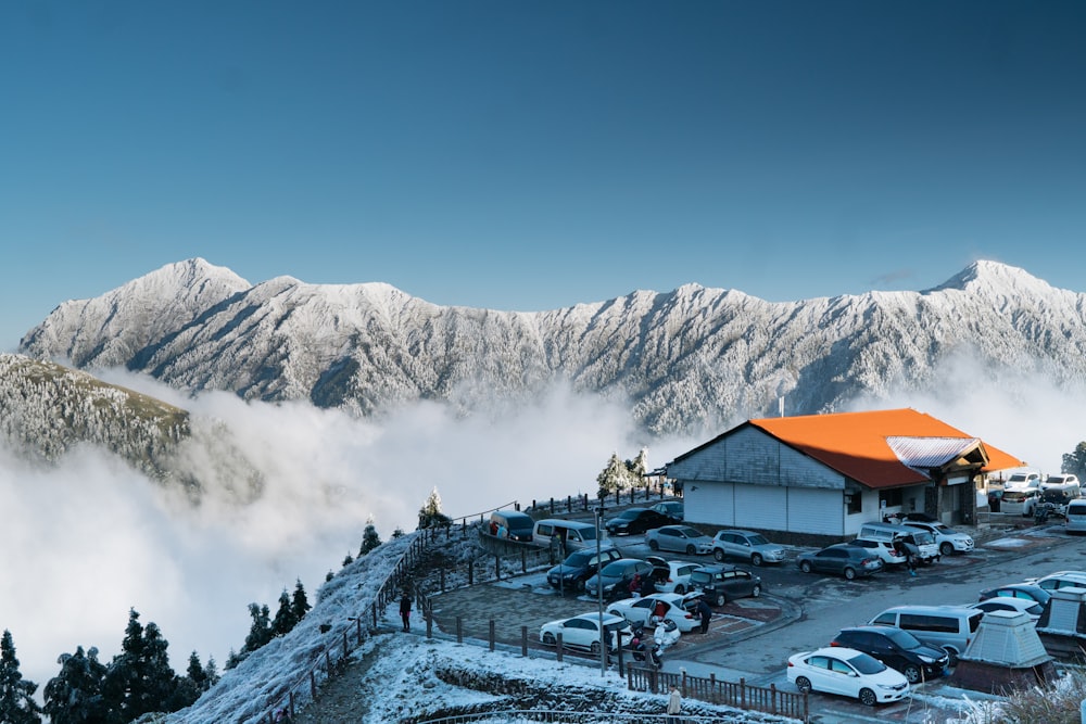 a snow covered mountain with cars parked in the parking lot