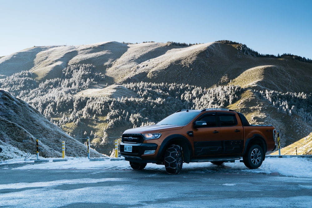 a truck is parked in the snow near a mountain