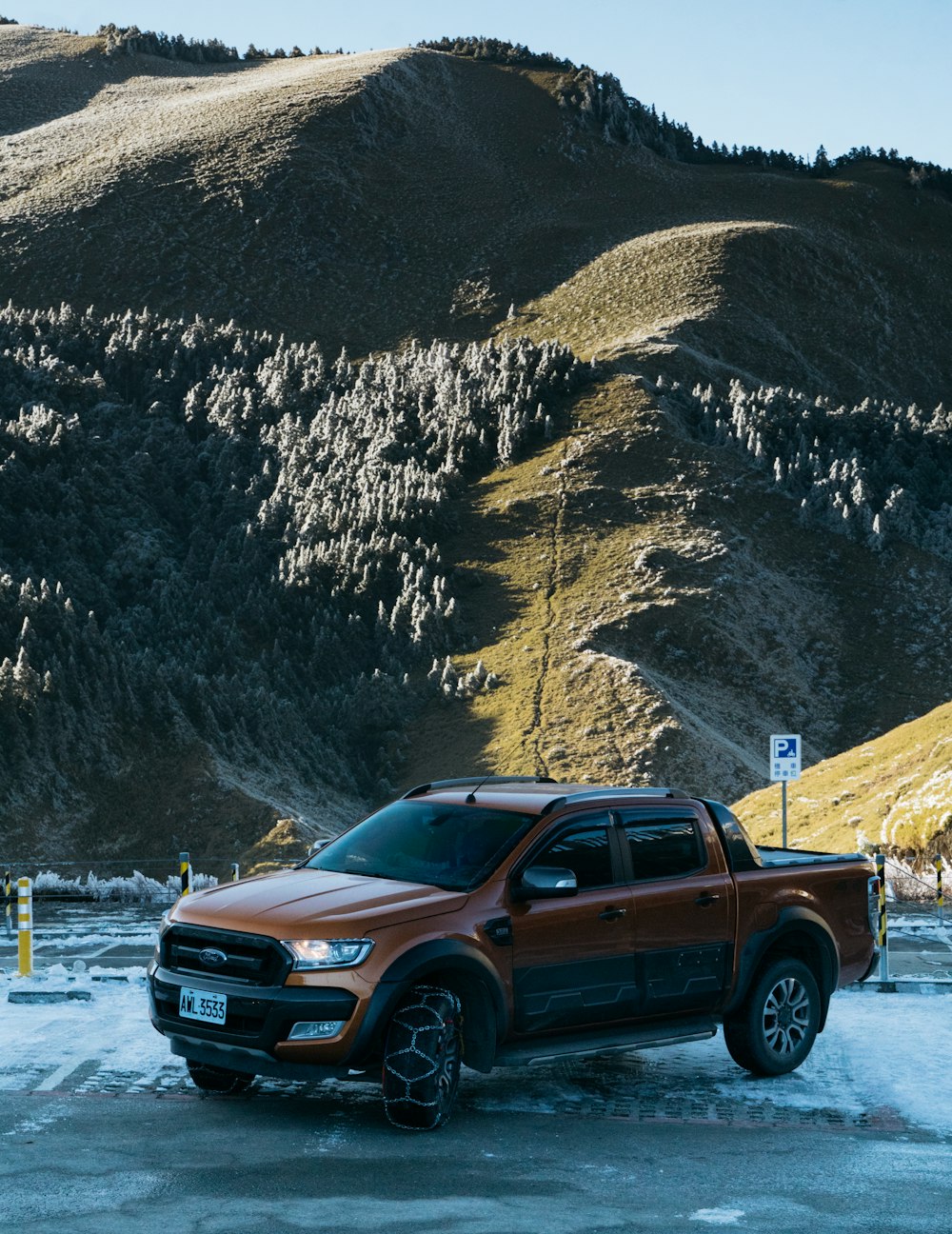 a red truck parked in front of a mountain