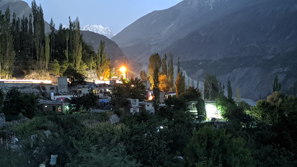 a night view of a village with mountains in the background